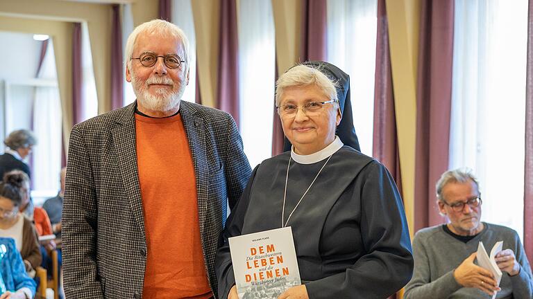 Buchvorstellung 'Dem Leben dienen': Anlässlich des 110-jährigen Geburtstages der Ritaschwestern beschloss die Kongregation, ein Buch über das gemeinsame Leben mit Würzburger Juden zu verfassen. Roland Flade (links im Bild) unterstützte mit seinem literarischen Können unsere Schwestern. Hier zusammen mit Schwester Rita-Maria Käß (Generaloberin der Gemeinschaft). Buchvorstellung 'Dem Leben dienen': Anlässlich des 110-jährigen Geburtstages der Ritaschwestern beschloss die Kongregation, ein Buch über das gemeinsame Leben mit Würzburger Juden zu verfassen. Roland Flade (links im Bild) unterstützte mit seinem literarischen Können unsere Schwestern. Hier zusammen mit Schwester Rita-Maria Käß (Generaloberin der Gemeinschaft).