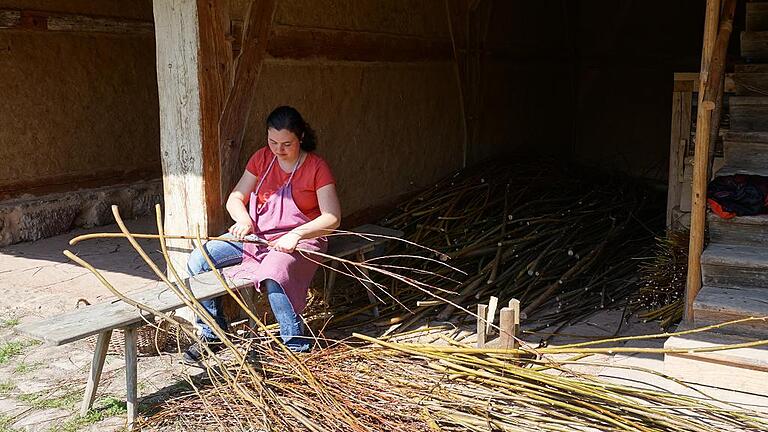 Auf dem Bauernhof schneidet eine Frau Weidenzweige für das Schweinegehege zu.