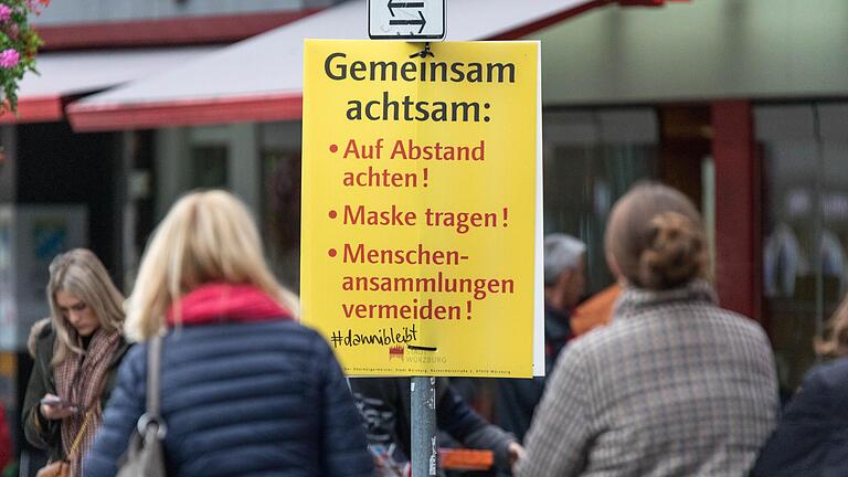 In der Würzburger Innenstadt hängen viele Plakate, die darauf hinweisen, gemeinsam achtsam zu sein und Abstand zu halten.