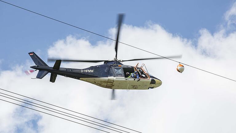 Per Hubschrauber installierte eine Fachfirma am Mittwoch im Auftrag der Autobahndirektion Nordbayern an der Hochspannungsleitung am Autobahntunnel 'Schwarzer Berg' bei Eltmann Flugwarnkugeln. Per Hubschrauber installierte eine Fachfirma am Mittwoch im Auftrag der Autobahndirektion Nordbayern an der Hochspannungsleitung am Autobahntunnel 'Schwarzer Berg' bei Eltmann Flugwarnkugeln.