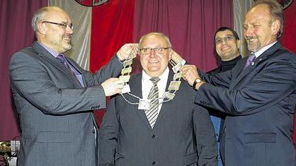 Im Nachhinein ein symbolträchtiges Foto: Zweiter Bürgermeister Franz Kuhn (links) hängte im Jahr 2012 gemeinsam mit Dritten Bürgermeister Hubert Schott (rechts) Siegfried Erhard die neue Amtskette um. Jetzt kann er sie an Franz Kuhn weiter geben, der sein Nachfolger wird. Im Hintergrund Schmuckdesigner Malte Meinck (Bad Kissingen).