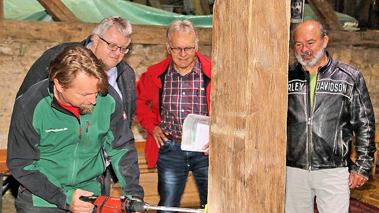 Der Wissenschaftler Georg Brütting (links) bohrte Löcher in zehn Balken der  Zehntscheune in Poppenlauer, um anhand der Bohrkerne das Alter zu  bestimmen.  Interessiert schauten der 2. Bürgermeister Wolfgang Rützel  (2. v. l.), Marktgemeinderat Winfried  Streit (3. v. l.) und Armin Gernert vom Bauamt  der Verwaltungsgemeinschaft Maßbach (rechts) ihm über die Schulter.Dieter Britz       -  Der Wissenschaftler Georg Brütting (links) bohrte Löcher in zehn Balken der  Zehntscheune in Poppenlauer, um anhand der Bohrkerne das Alter zu  bestimmen.  Interessiert schauten der 2. Bürgermeister Wolfgang Rützel  (2. v. l.), Marktgemeinderat Winfried  Streit (3. v. l.) und Armin Gernert vom Bauamt  der Verwaltungsgemeinschaft Maßbach (rechts) ihm über die Schulter.Dieter Britz