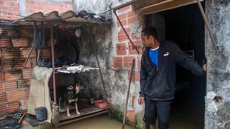 454140304.jpg       -  Ein Mann steht in seinem überfluteten Haus nach schweren Regenfällen. Bei schweren Unwettern sind im Südosten Brasiliens mehrere Menschen ums Leben gekommen.