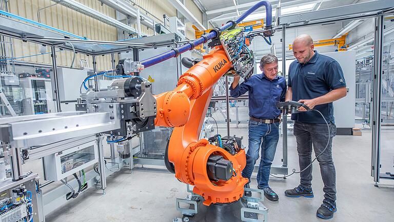 Auf der Anlage im Montagebereich werden Rotoren für Elektromotor in Lastwagen gebaut. Der Roboter nimmt das hergestellte Teil anschließend vom Band und legt es in eine Messmaschine, um es dort zu überprüfen. Auf der Anlage im Montagebereich werden Rotoren für Elektromotor in Lastwagen gebaut. Der Roboter nimmt das hergestellte Teil anschließend vom Band und legt es in eine Messmaschine, um es dort zu überprüfen. 