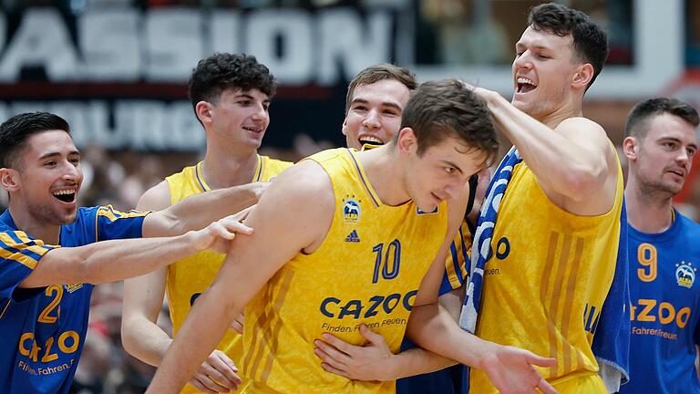 Die Spieler von Alba Berlin herzen ihren Matchwinner Tim Schneider.