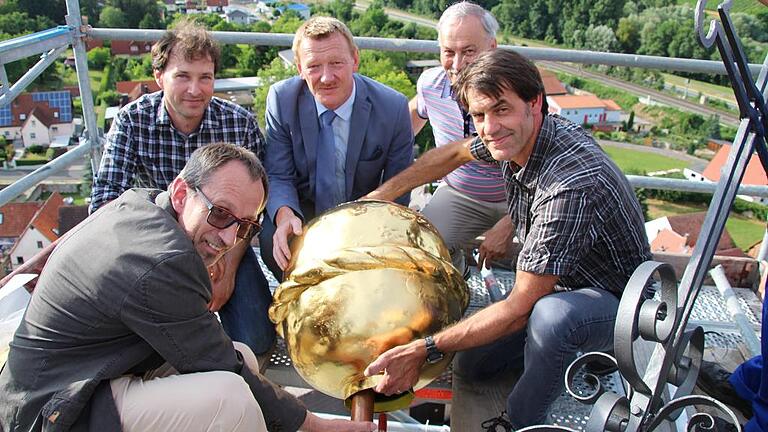 Endlich wieder an ihrem Platz: die goldene Turmkugel. Im Bild (von links): Roland Schmitt, Georg Böswald-von Brunn, Peter Juks, Manfred Deppisch und Restaurator Christoph Schädel.