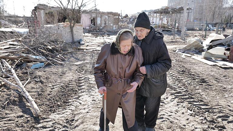 Zinaida und ihr Mann Mischa vor Häusern in Schytomyr, die durch einen Raketenangriff zerstört wurden.