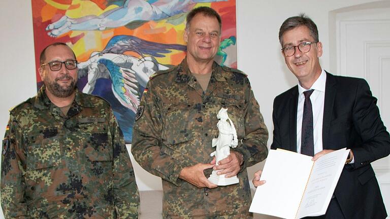 Oberbürgermeister Christian Schuchardt (rechts) ehrt den scheidenden Brigadegeneral Michael Podzus (Mitte) mit dem Tanzenden Schäfer. Links im Bild ist Podzus' Nachfolger Brigadegeneral André Abed.