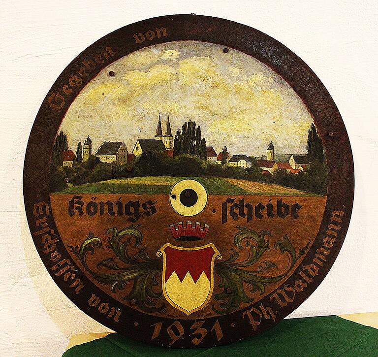 Die von Siegfried Krämer im Jahr 1931 gestiftete Königsscheibe der Gerolzhöfer Schützen. Wie auch schon auf der von ihm geschossenen Königsscheibe von 1928, als er Schützenkönig wurde, wurde auch hier sein Name im Nationalsozialismus übermalt. Bei bestimmtem Lichteinfall schimmern die Buchstaben noch leicht durch. Die von Siegfried Krämer im Jahr 1931 gestiftete Königsscheibe der Gerolzhöfer Schützen. Wie auch schon auf der von ihm geschossenen Königsscheibe von 1928, als er Schützenkönig wurde, wurde auch hier sein Name im Nationalsozialismus übermalt. Bei bestimmtem Lichteinfall schimmern die Buchstaben noch leicht durch.
