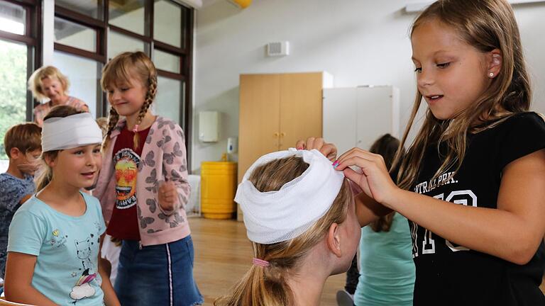 Die praktischen Erste Hilfe-Maßnahmen kommen im Ferienspaß gut an und der Kopfverband war schnell gewickelt.