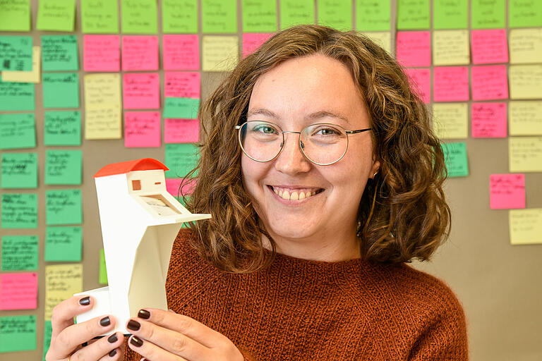 Hier war er noch ein kleines Modell, inzwischen ist er ein realer hybrider Briefkasten: Franzisca Maas präsentiert den 'hubbel'. Im Hintergrund: unzählige Post-Its mit Ideen zur Entwicklung des Projekts.