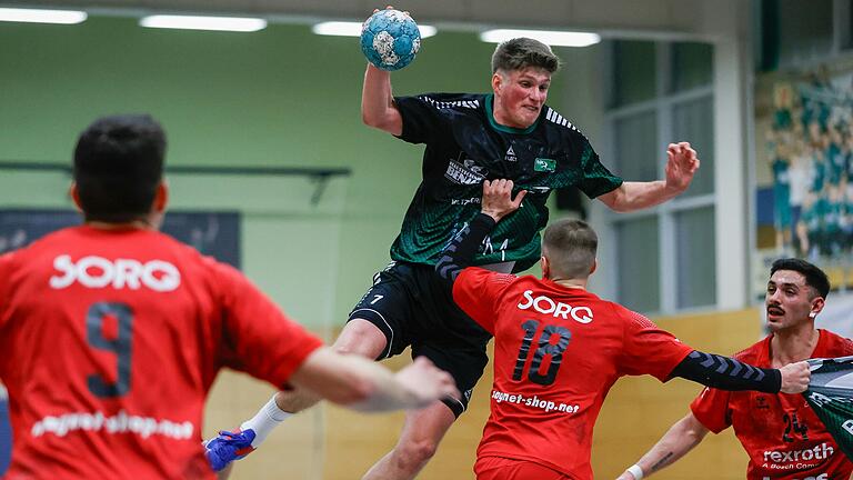 Lohrs Fabian Zehnter (Nummer 18) im doppelhändigen Abwehreinsatz. Mit seiner linken Hand stemmt er sich gegen den Rimparer Florian Schmidt (Zweiter von links), in der rechten hat er noch ein Rimpar Trikot. Weiter im Bild: die Lohrer Jakob Röder (links) und Bernardo Gomes de Almeida (rechts).