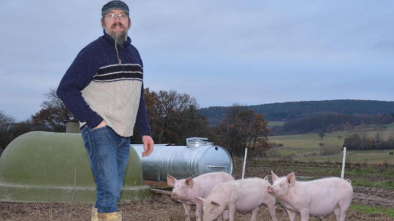 Burkard Mahlmeister aus Stangenroth vermarktet seit 1993 sein erzeugtes Fleisch und die selbst produzierten Wurstwaren selbst. Hier steht er in einem Freilandgehege seines Hofs, in dem diese drei Schweine zu Hause sind.  Foto: Kathrin Kupka-Hahn       -  Burkard Mahlmeister aus Stangenroth vermarktet seit 1993 sein erzeugtes Fleisch und die selbst produzierten Wurstwaren selbst. Hier steht er in einem Freilandgehege seines Hofs, in dem diese drei Schweine zu Hause sind.  Foto: Kathrin Kupka-Hahn