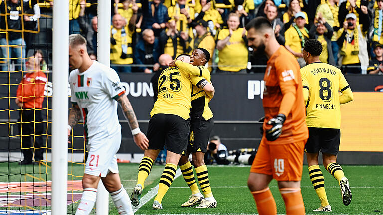 Borussia Dortmund - FC Augsburg.jpeg       -  Gewohntes Bild an diesem Nachmittag: Die Spieler von Borussia Dortmund jubeln, die Augsburger holen den Ball aus dem Netz.