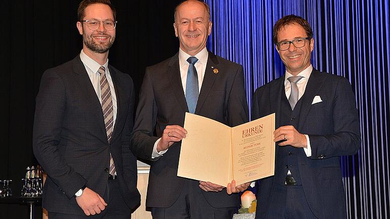 Reiner Türk Auszeichnung Machon Gros       -  Eine hohe Auszeichnung hatte Verbandspräsident Jürgen Gros (rechts) zur Verabschiedung von Reiner Türk mitgebracht. Glückwünsche gab es zudem vom Aufsichtsratsvorsitzenden Christian Machon (links).