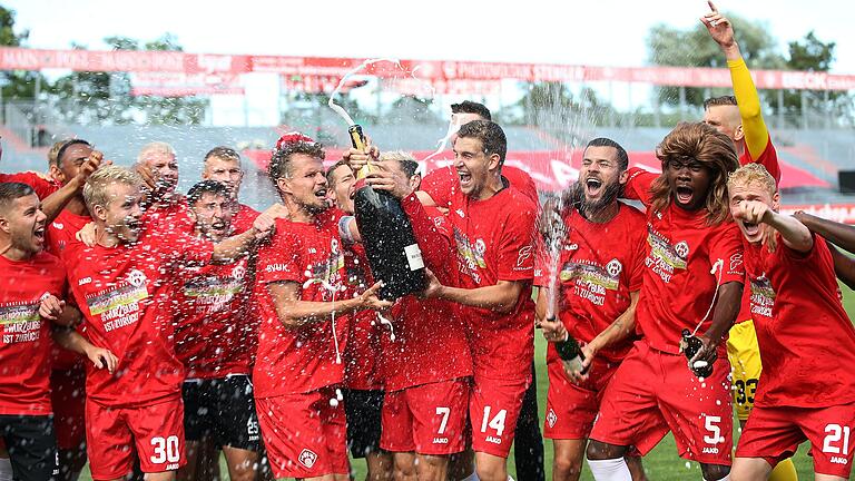 Korken knallen lassen: Die Würzburger Kickers bejubeln den Aufstieg in die Zweite Bundesliga nach dem dramatischen 2:2 gegen den Halleschen FC.