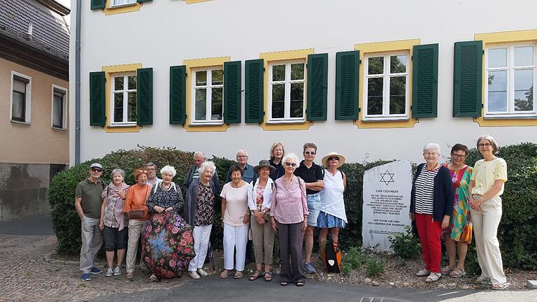 Die Exkursionsteilnehmer an denkwürdigem Ort in Höchberg: ehemalige Präparandenschule, Stolpersteine und Gedenkstein an die Opfer des Nationalsozialismus.