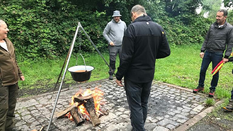 Die Tomatensoße köchelt über dem Lagerfeuer.