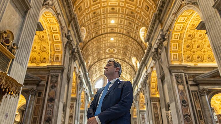 Bayerns Ministerpräsident Markus Söder im Vatikanstaat.jpeg       -  Söder gibt im Petersdom den Mann, der bewundernd auf die einmalige Pracht blickt. Nicht im Bild: Das Baugerüst, das Söder eigentlich anschaut.