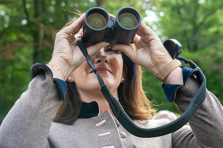 Mit dem Fernglas besah sich Michaela Kaniber die Trockenschäden im Wald entlang des Nordtraufs des Steigerwalds.