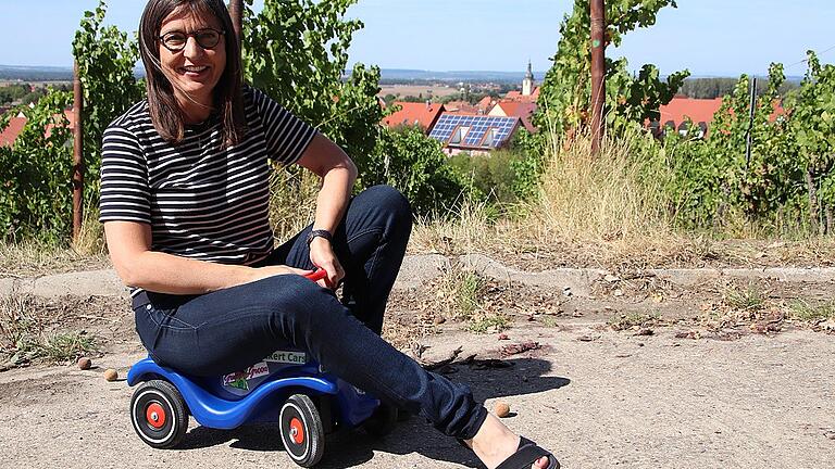 Barbara Becker präsentiert das Bobby-Car, mit dem Kinder am Wahlstand spielen können.