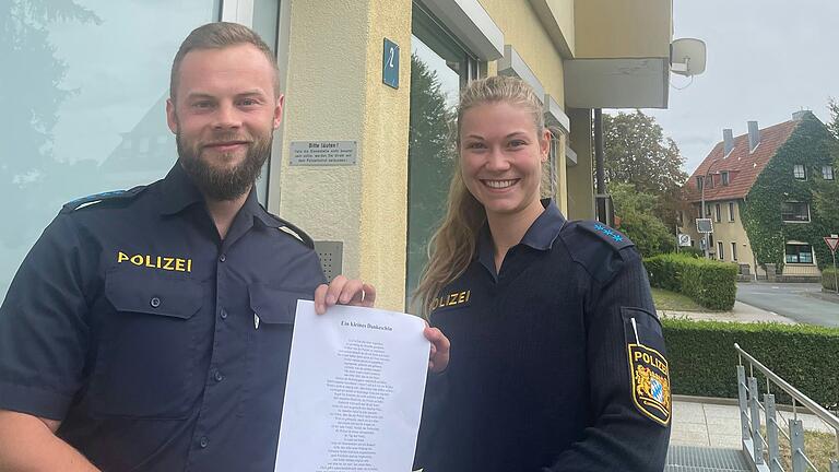 Polizist Sebastian Flügel (zukünftiger stellvertretender Leiter der Polizeistation Bad Königshofen) und Polizistin Milena Nußbaum mit dem Gedicht eines Unbekannten.