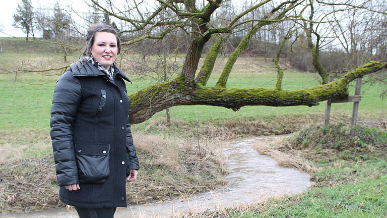 Nicole Weissenseel-Brendler an ihrem Lieblingsplatz, an einem windschief gewachsenen Baum am renaturierten Volkachbach unterhalb des Dingolshäuser Sportgeländes. Der Baum ist für sie ein Zeichen von Individualität. Und diese ist ihr wichtig.