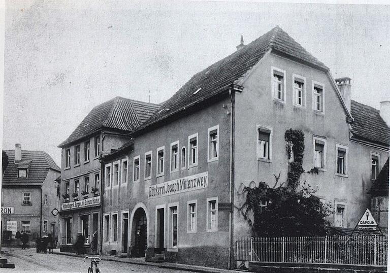 Zwischen der Schreinerei Hacker (zweites Haus von links) und der ehemaligen Bäckerei Mittenzwey (großes Haus rechts) stand in der Marktstraße in Gerolzhofen ein heute überbautes Gebäude. Dort betrieb die Jüdin Fanny Braun ein Putzmachergewerbe, das sie im März 1885 angemeldet hat.