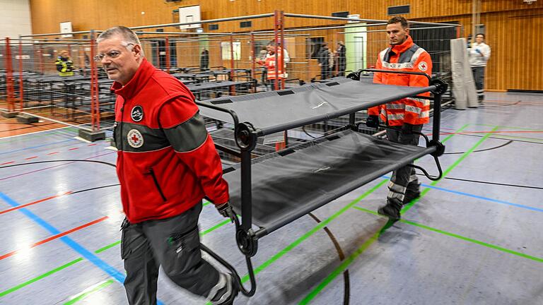 Am Freitagnachmittag begannen Helferinnen und Helfer des Technischen Hilfswerks, des Bayerischen Roten Kreuzes, der Feuerwehr und des Landratsamts damit, die Main-Spessart-Halle in Marktheidenfeld als Notunterkunft für Geflüchtete einzurichten. Am Freitagnachmittag begannen Helferinnen und Helfer des Technischen Hilfswerks, des Bayerischen Roten Kreuzes, der Feuerwehr und des Landratsamts damit, die Main-Spessart-Halle in Marktheidenfeld als Notunterkunft für Geflüchtete einzurichten.