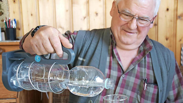 Paul Schmitt nutzt seinen Flaschenhalter täglich. Federhalterung und Henkel ermöglichen auch ein bequemes Einschenken ins Glas.  Foto: Heike Beudert       -  Paul Schmitt nutzt seinen Flaschenhalter täglich. Federhalterung und Henkel ermöglichen auch ein bequemes Einschenken ins Glas.  Foto: Heike Beudert