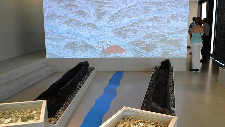 Lebendige Feuerwehrgeschichte - Auf einer Leinwand wird der gesamte Mainlauf gezeigt. Dort „entspringt“ auch der Fluss, der sich sich als blaues Band durch die Ausstellungsräume windet. Flankiert an seiner „Quelle“ von Einbäumen aus dem Mainschotter. Lebendige Feuerwehrgeschichte - Auf einer Leinwand wird der gesamte Mainlauf gezeigt. Dort „entspringt“ auch der Fluss, der sich sich als blaues Band durch die Ausstellungsräume windet. Flankiert an seiner „Quelle“ von Einbäumen aus dem Mainschotter.