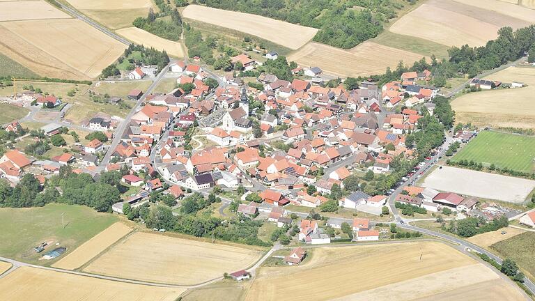 Die Kirche thront über den Häusern der Einwohner eines Dorfes, das sich dieses Mal im Grabfeld befindet. Die Kirche thront über den Häusern der Einwohner eines Dorfes, das sich dieses Mal im Grabfeld befindet.