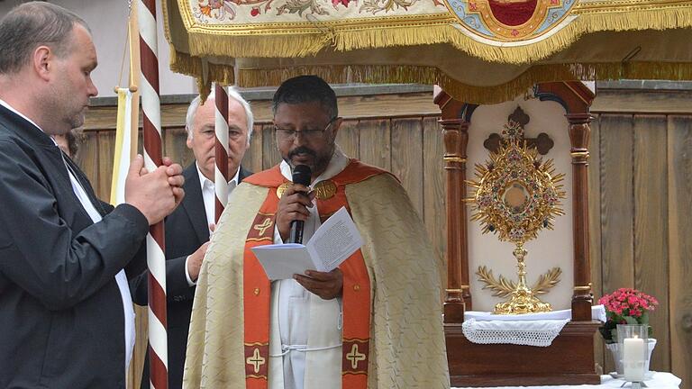 Pfarrer Pater Joe las am Hausaltar der Familie Reichert in Althausen das Evangelium. Die goldenen Monstranz stand im 'Sakramentshäuschen'.