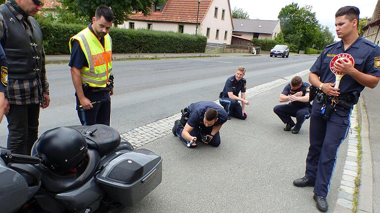 Während ein Polizist Gas gibt, beobachten weitere Beamte, wie die Klappen im Auspuff reagieren.