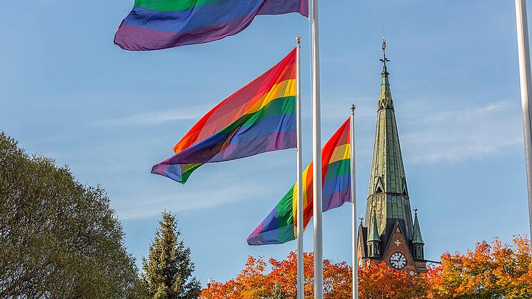 Regenbogenflagge vor einer Kirche. In Würzburg werden schon zum zweiten Mal gleichgeschlechtliche Paare gesegnet.