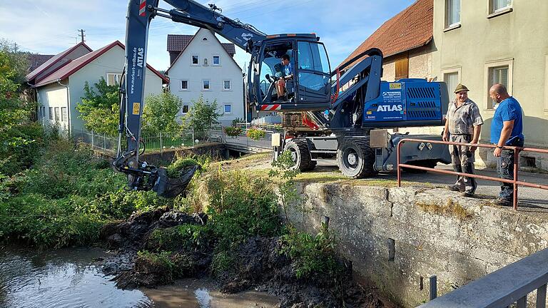 Gemeinderatsmitglieder aus Tretzendorf organisierten die Reinigung des Bachbetts: Daniel Markert beim Baggern, während Hans Albert und Alexander Diem auf die nächsten Fuhren für ihre Traktoren warten. Die Feinarbeit im Bachbett blieb dem Jüngsten in der Runde, Max Benkert, vorbehalten.