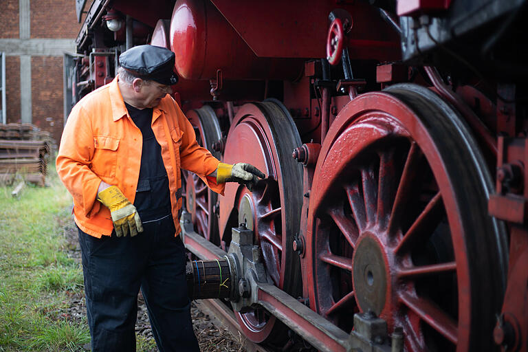 Heizer Klaus Röhrich am Fahrwerk der Dampflokomotive aus dem Jahr 1943 - ein Kriegsmodell.