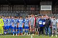 Auf dem Foto sind die Mannschaften von der (SG) SV Viktoria Weigenheim (graue Spielkleidung) und der (SG) TG Höchberg (blaue Spielkleidung) zu sehen. Vorne stehen mit schwarzer Jacke BFV-Kreis-Jugendleiter Claus Höpfner und links daneben der Weigenheimer Coach Andreas Stegmüller.