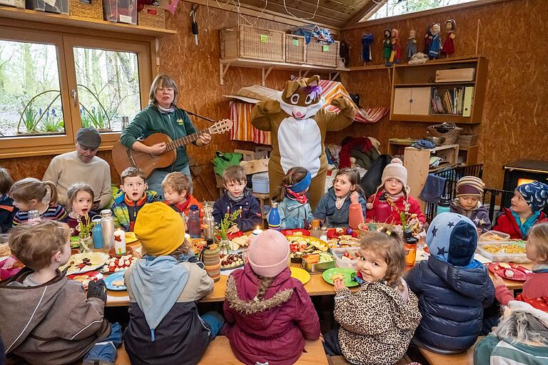 Im Waldkindergarten Gerolzhofen überraschte Sabine Effertz als Osterhase verkleidet die Kinder am gedeckten Tisch. Mit im Bild ist Erzieher Ralph Theobald (hinten von links) und Kindergartenleiterin Ulli Hillebrand zu sehen.