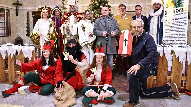 Die Aktion ein 'Baum für Schweinfurt' ist eröffnet. Das Foto zeigt den Projektleiter Rüdiger Wolf (kniend), dessen Team sowie Center-Leiter Manfred Saal (Bildmitte, grauer Mantel) Ralf Klimaszyk (Bürobedarf Quadro, rechts daneben) und Sennfelds Bürgermeister Oliver Schulze (zweiter von rechts).