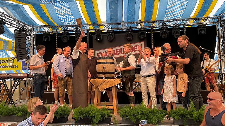 Bürgermeister Thomas Stamm (Dritter von links, mit Schürze) brauchte dreieinhalb Schläge, um die Messe zu eröffnen. Gemeinsam mit Brauereichefin Maria Martin, Vertretern der Brauerei und der Festwirtsfamilie Papert stieß er auf die Messe an. Bei der Festbierprobe vergangene Woche hatte Stamm vier Schläge gebraucht.