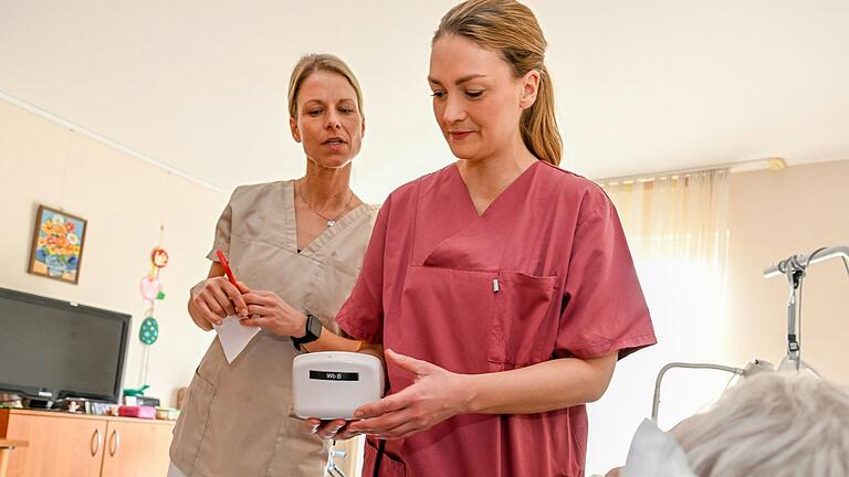 Pflegedienstleitung Marie-Jacqueline Seus (links) beobachtet, wie Gesundheitsministerin Judith Gerlach (CSU) bei einer Bewohnerin des Seniorenstifts in Hafenlohr den Blutdruck misst.&nbsp;