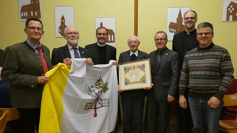 Im Rahmen des Neujahrsempfangs der Pfarrgemeinde Nordheim wurde auch der 90. Geburtstag von Pfarrer Karl Hauck (Mitte) nachträglich mitgefeiert. Als Geschenke bekam er unter anderem eine Vatikanfahne und den apostolischen Segen von Papst Franziskus. Im Bild (von links) der stellvertretende Landrat Peter Suckfüll, Egon Bauß, Sprecher des Gemeindeforums Nordheim, Pfarrvikar Paul Reder, Ruhestandspfarrer Karl Hauck, Bürgermeister Thomas Fischer, Pfarrer Thomas Menzel und Andreas Weber, Vorsitzender des Pfarreiengemeinschaftsrats.