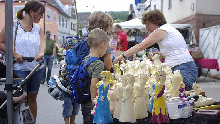 Lydia Baier (r.) zeigt jungen Interessierten, wie ihre selbst gegossenen Figuren farbig gestaltet werden können.  Fotos: Wifnried Ehling       -  Lydia Baier (r.) zeigt jungen Interessierten, wie ihre selbst gegossenen Figuren farbig gestaltet werden können.  Fotos: Wifnried Ehling