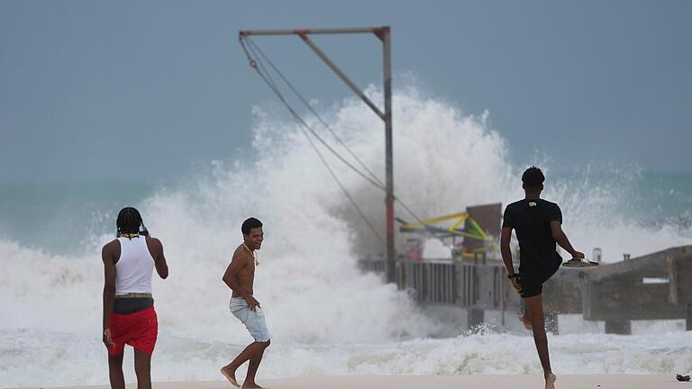 Hurrikan auf Barbados       -  Jugendliche am Strand, während der Hurrikan &bdquo;Beryl&rdquo; durch ihre Stadt zieht.