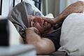 Ein Mann reibt sich die Augen im Bett       -  Unruhiger Schlaf wegen der Zeitumstellung? Bewegung und frische Luft sowie der Verzicht auf Mittagsschläfchen können hier helfen.