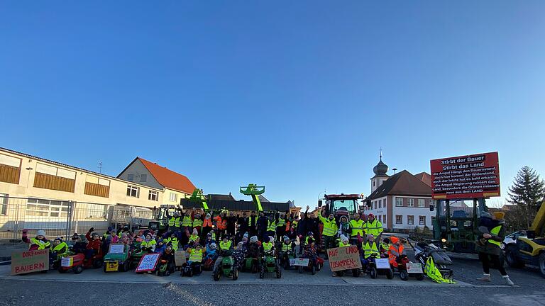 In Donnersdorf fuhren am Mittwochvormittag (10. Januar 2024) knapp 50 Kindergartenkinder auf Trettraktoren und Bobbycars vom Haus der Kinder bis zur Ortsmitte. Mit dabei waren auch mehrere große Schlepper örtlicher Landwirte.