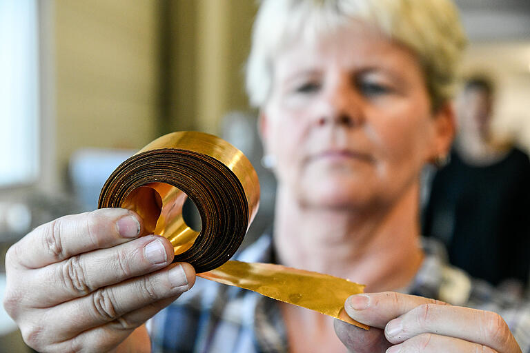 Bis der Barren ein schmales Band ist: Susanne Wegler wickelt das Gold nach dem Walzen auf.