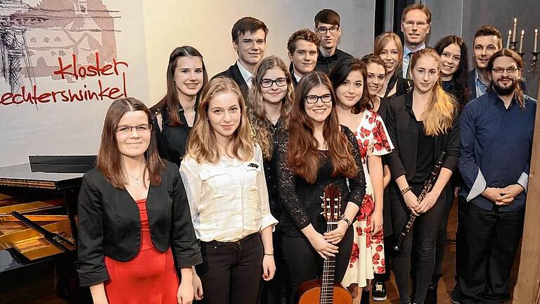 Gemeinsames Konzert zur Vorbereitung für das Abitur. Schülerinnen und Schüler des Martin-Pollich-Gymnasiums nach dem Konzert in Wechterswinkel gemeinsam mit den Musiklehrern Urs John und Marcel Steinrichter (von rechts) sowie Schulleiter Robert Jäger (hintere Reihe, rechts).