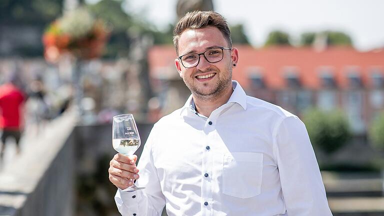 Dominic Scheffel ist aus Kassel zu Besuch in Würzburg und genießt den Weißwein auf der Alten Mainbrücke.